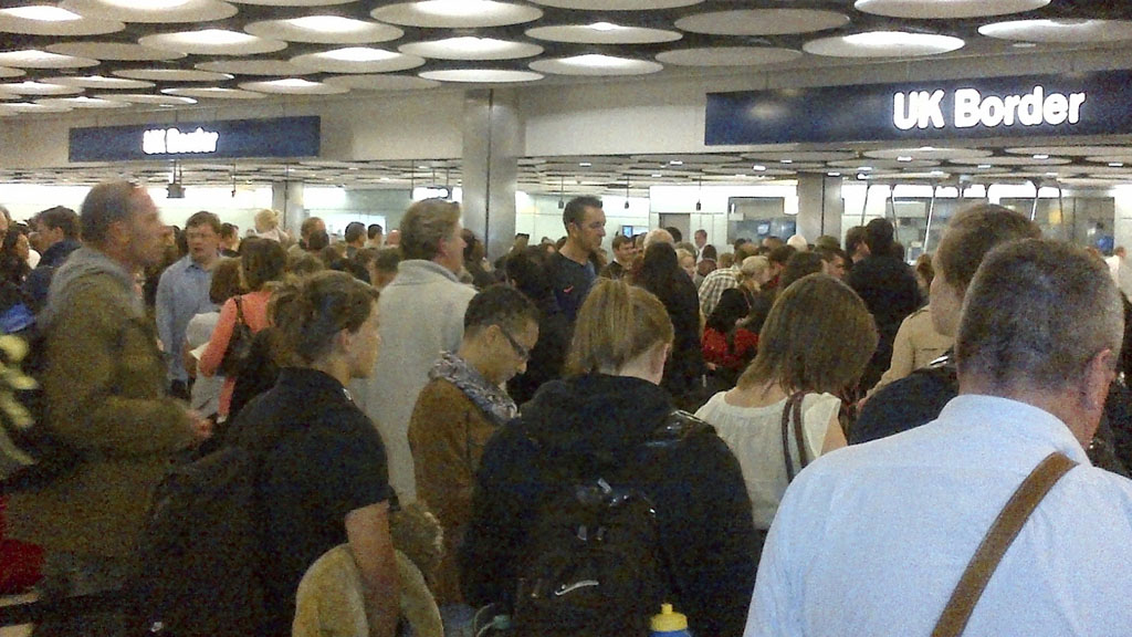 Travellers queue to be processed by UK Border Agency immigration control officers at Heathrow airport's Terminal 5 in London