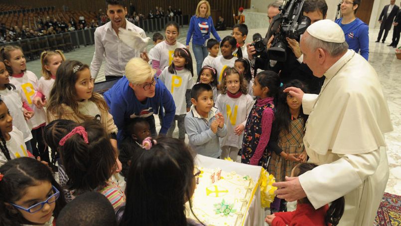 Pope Francis blows a candle on a cake during an audience with children assisted by volunteers of Santa Marta institute in Paul VI hall at the Vatican