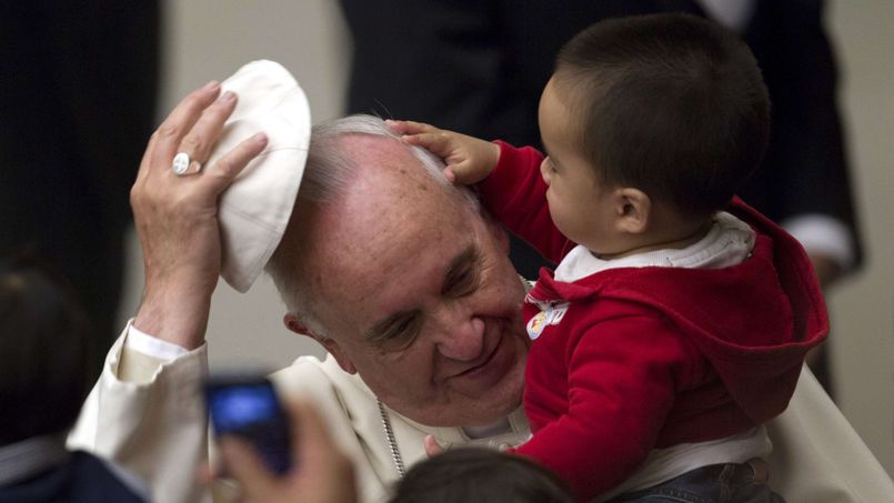 Pope Francis has his skull cap removed by a child during an audience with children in the Vatican