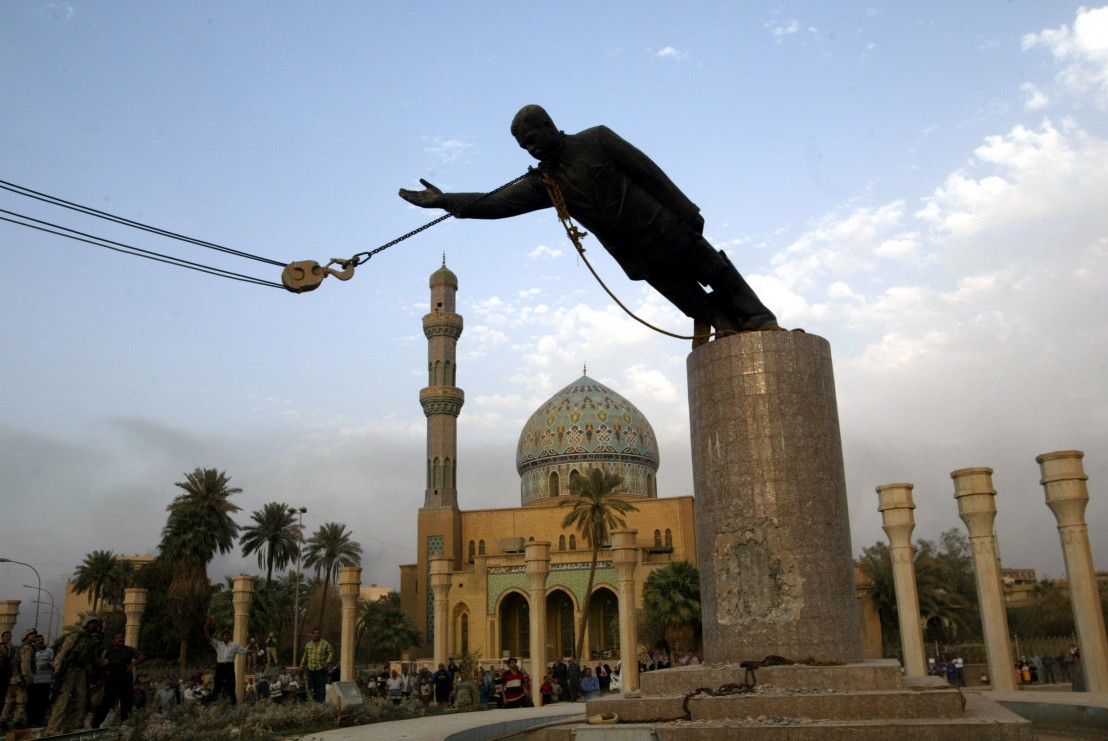 A statue of Iraq's President Saddam Hussein falls as it is pulled down in central Baghdad April 9, 2..