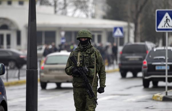 An armed man patrols at the Simferopol airport in the Crimea region