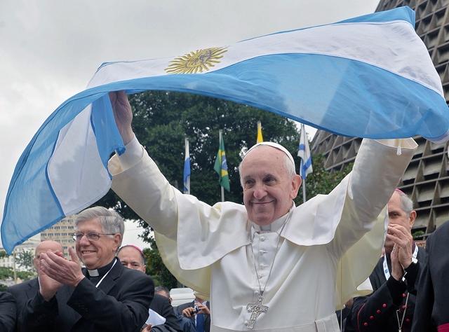 Pope Francis flutters an Argentine flag outside the Metropolitan cathedral in Rio de Janeiro, Brazil on July 25, 2013. The first Latin American and Jesuit pontiff arrived in Brazil mainly for the huge five-day Catholic gathering World Youth Day. AFP PHOTO / LUCA ZENNARO - POOL